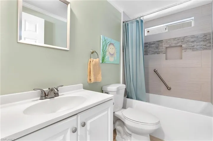 Full bathroom featuring shower / tub combo, vanity, and crown molding