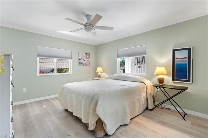 Bedroom featuring ornamental molding, light wood-style floors, and ceiling fan