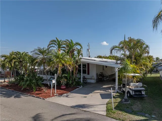 Manufactured / mobile home featuring driveway and an attached carport
