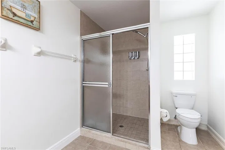 Full bathroom with a stall shower and light tile patterned flooring
