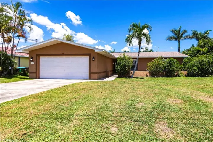 Single story home featuring stucco siding, a front yard, concrete driveway, and an attached garage