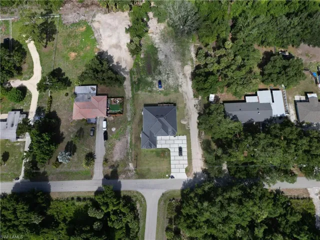 Newly constructed property featuring a dark-toned roof and a geometric paver driveway