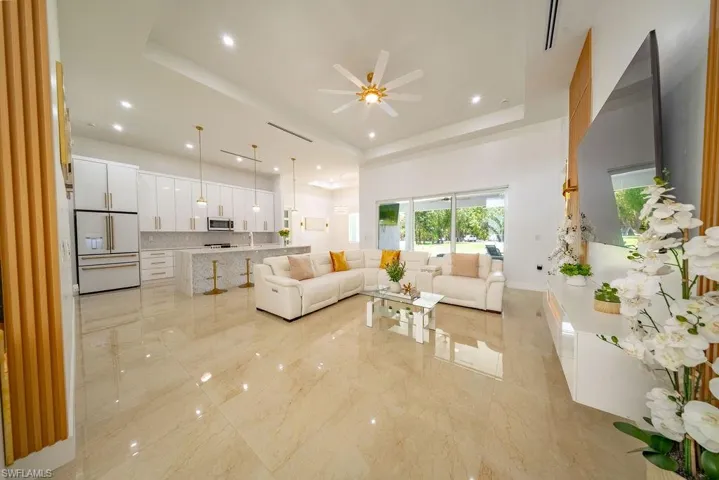 Open-concept living space with large format tile flooring and recessed lighting