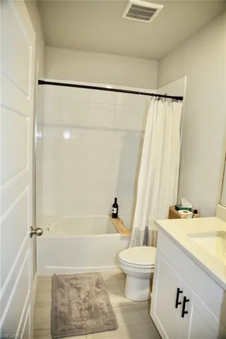 Full bath with vanity and shower / bath combination with curtain