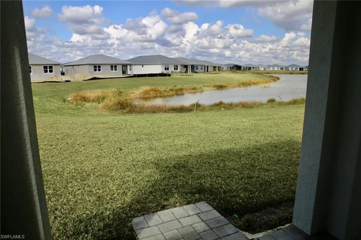 View of grassy yard featuring a residential view and a water view