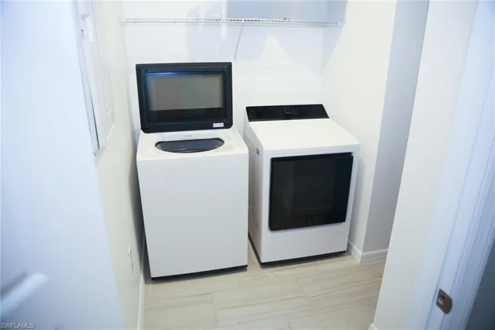 Laundry room featuring separate washer and dryer and baseboards