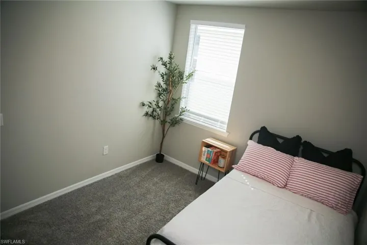 Bedroom featuring dark carpet and baseboards