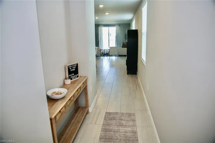 Corridor with baseboards and recessed lighting