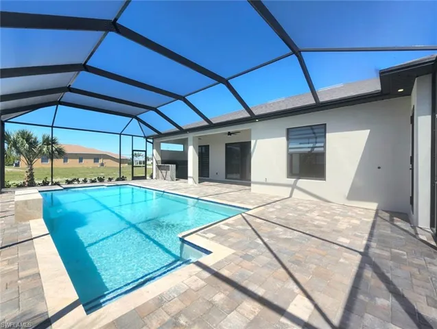 Outdoor pool featuring a patio area, glass enclosure, and a ceiling fan