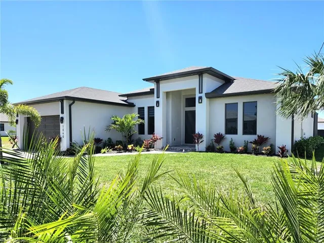 Prairie-style house with a front lawn, a garage, and stucco siding