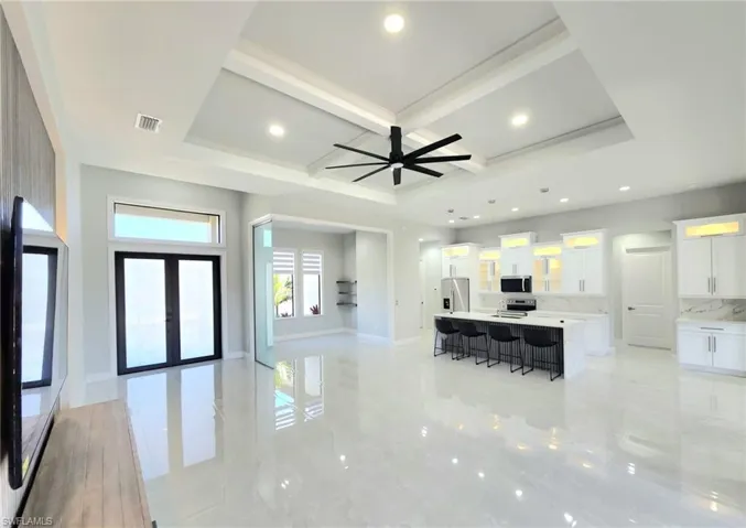 Living area featuring coffered ceiling, baseboards, visible vents, and recessed lighting
