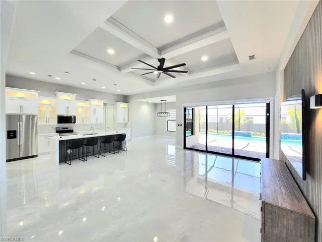 Living room featuring beamed ceiling, a ceiling fan, recessed lighting, coffered ceiling, and baseboards
