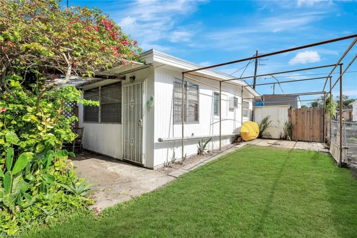 Unit One carport area with removable mesh covering, along with a covered patio area.
