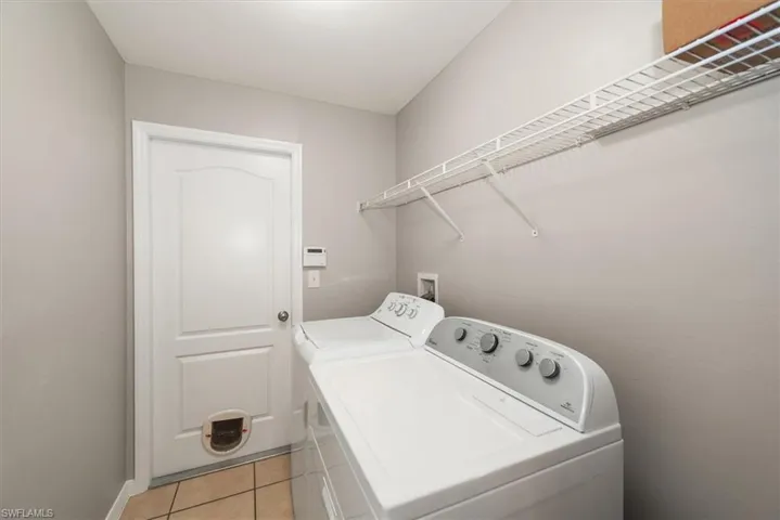 Laundry area with light tile patterned floors and washer and dryer