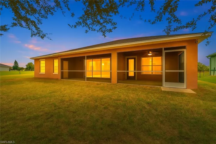 Back of property featuring a yard, stucco siding, and a sunroom