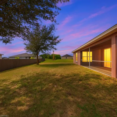 Yard at dusk featuring a sunroom