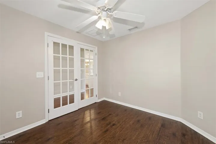 Empty room with dark wood-style flooring and baseboards