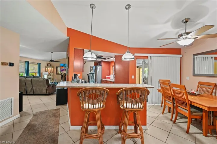 Kitchen featuring pendant lighting, kitchen peninsula, a healthy amount of sunlight, and a breakfast bar area