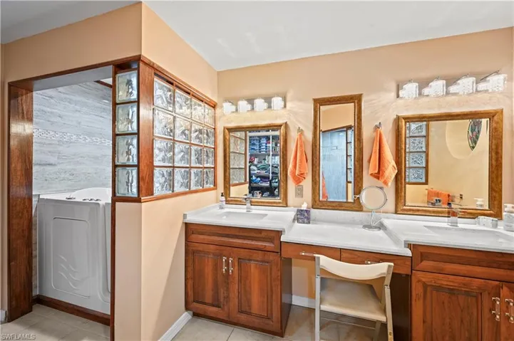 Bathroom with a bathing tub, vanity, washer / dryer, and tile patterned floors