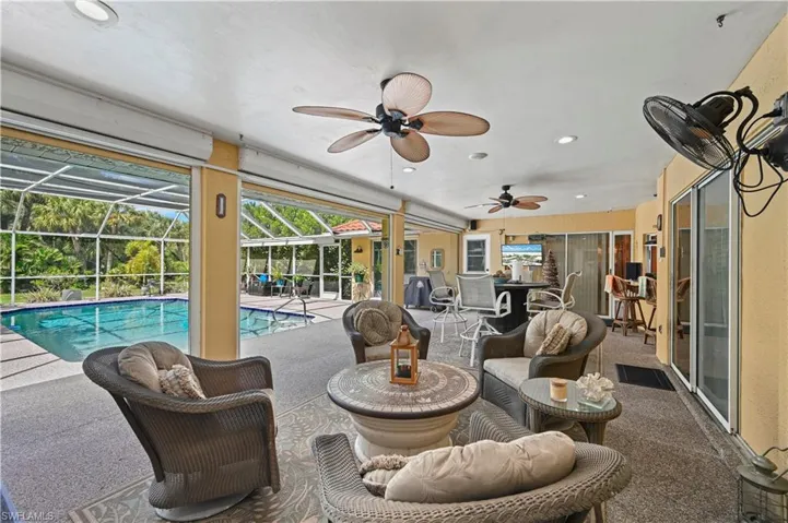 View of swimming pool featuring ceiling fan