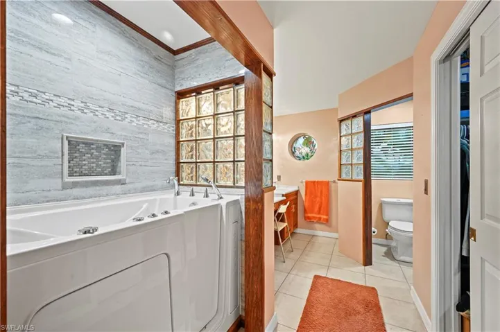Bathroom featuring a bathing tub, tile patterned flooring, vanity, and toilet