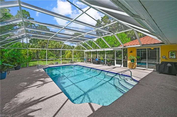 View of swimming pool featuring a lanai, a patio area, and grilling area