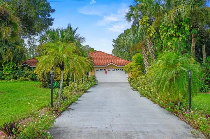 View of front facade featuring a front lawn and a garage