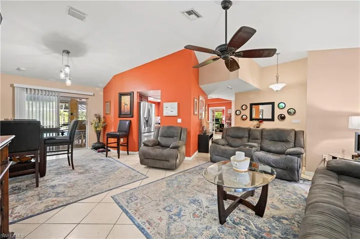 Tiled living room with vaulted ceiling and ceiling fan