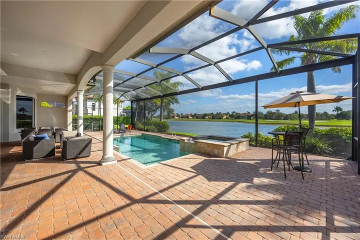 View of swimming pool featuring a sunroom, a lanai, a water view, and a patio area