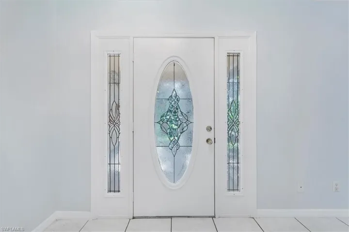 Tiled foyer entrance featuring baseboards