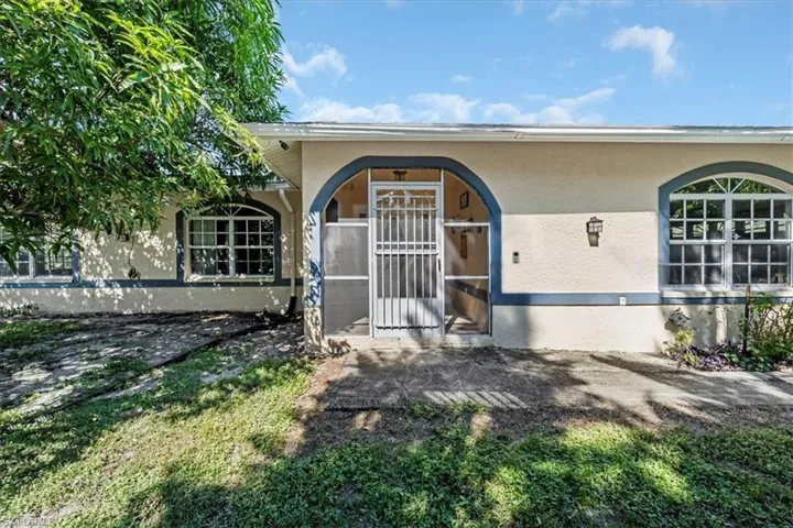 Doorway to property featuring stucco siding