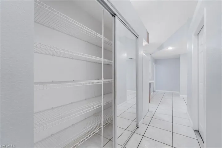 Hallway featuring light tile patterned floors and baseboards