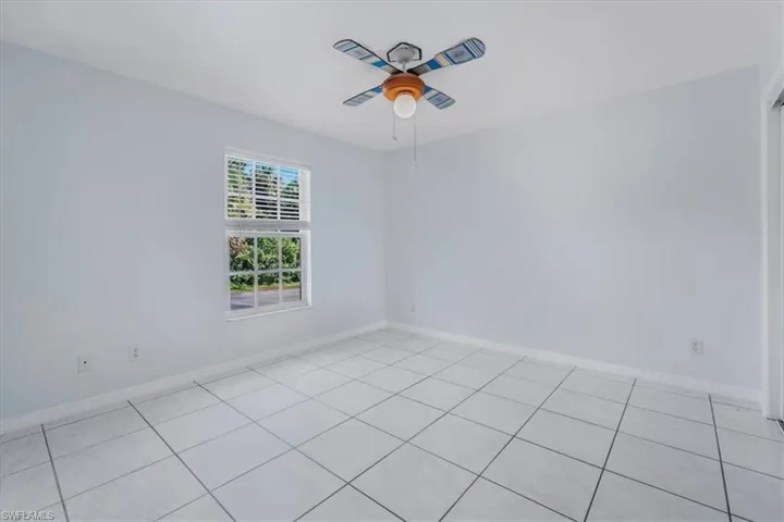 Unfurnished room featuring light tile patterned floors and a ceiling fan