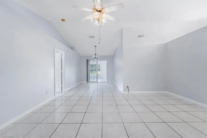 Unfurnished room featuring light tile patterned floors, vaulted ceiling, and ceiling fan