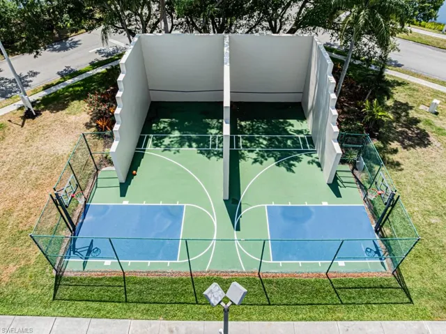 View of basketball court with community basketball court, fence, and a yard