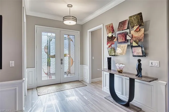 Office area with crown molding, light wood-style floors, and ceiling fan