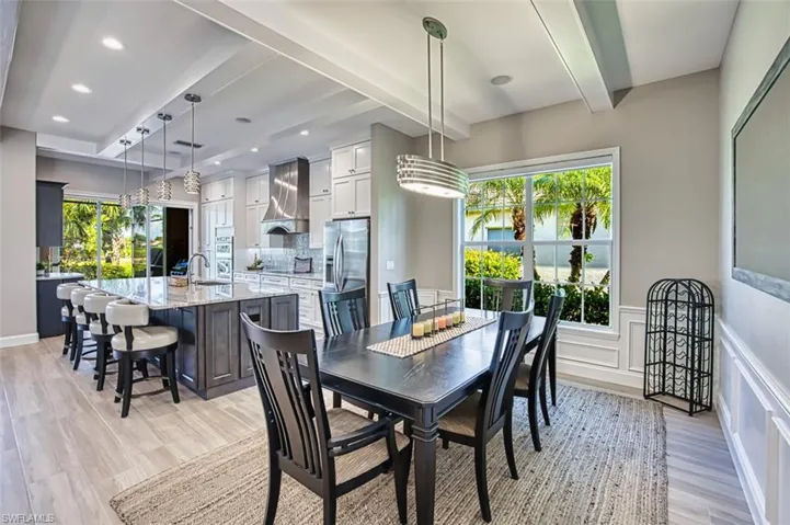 View of pool with a patio area, a sunroom, grilling area, glass enclosure, and a pool with connected hot tub