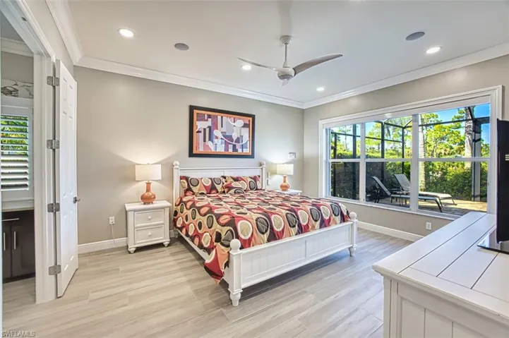 Carpeted bedroom featuring ornamental molding, a closet, and a ceiling fan