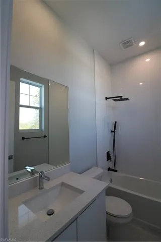 Full bathroom with vanity, toilet, and  shower combination