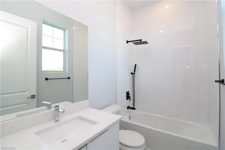 Full bathroom featuring washtub / shower combination, toilet, and vanity