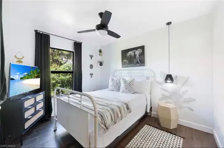 Bedroom with dark wood finished floors and a ceiling fan