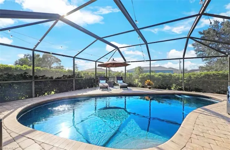 Outdoor pool featuring a sunroom, a lanai, and a patio