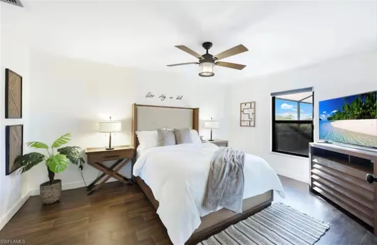 Bedroom featuring a ceiling fan and dark wood-style flooring