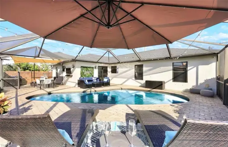 View of pool with a sunroom, patio surround, and a lanai