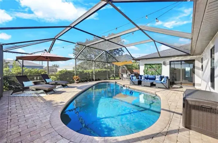 Outdoor pool featuring a lanai, a sunroom, and a patio area
