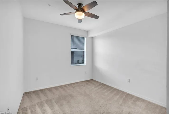 Spare room featuring light carpet and ceiling fan