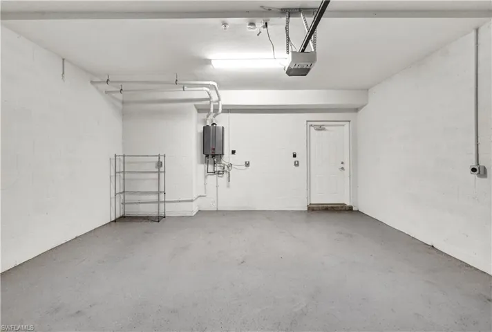 Garage featuring tankless water heater and a garage door opener