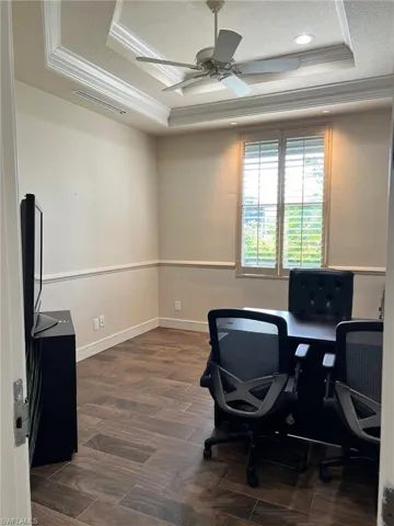 Home office featuring a tray ceiling, ornamental molding, ceiling fan, and a textured ceiling