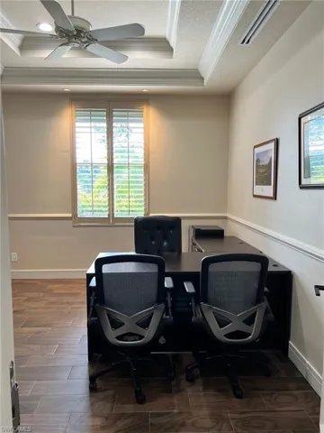 Office space featuring crown molding, a tray ceiling, a ceiling fan, a textured ceiling, and recessed lighting