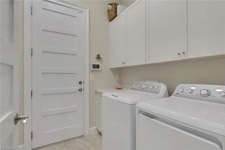 Laundry room featuring washing machine and clothes dryer and cabinet space